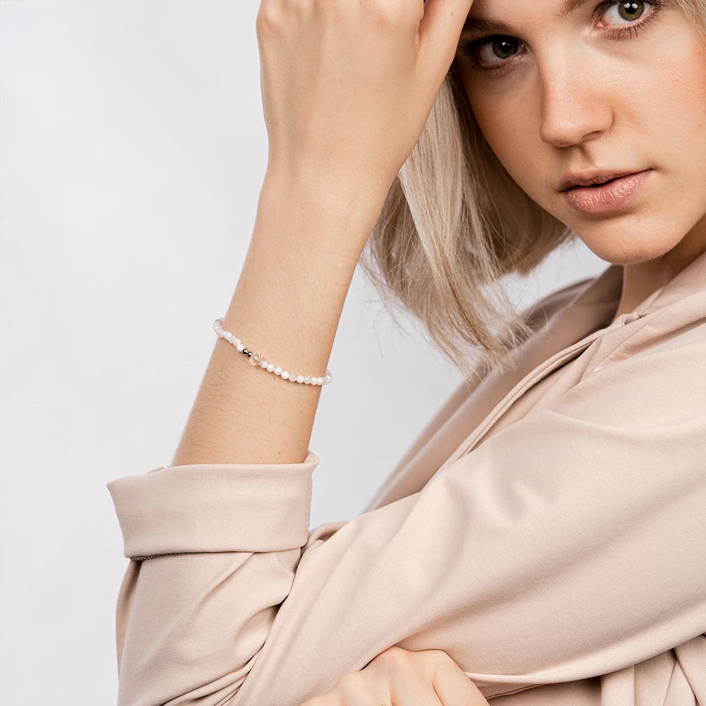 Goldobsidian-Armband in der Hand gehalten, nahe am Körper präsentiert.