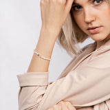 Goldobsidian-Armband in der Hand gehalten, nahe am Körper präsentiert.